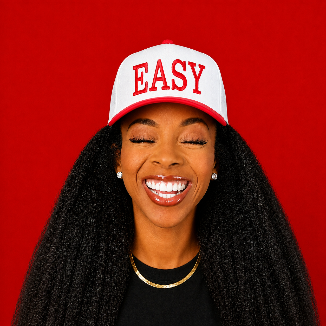 Coach Gigi smiling in a white EASY cap against a red background